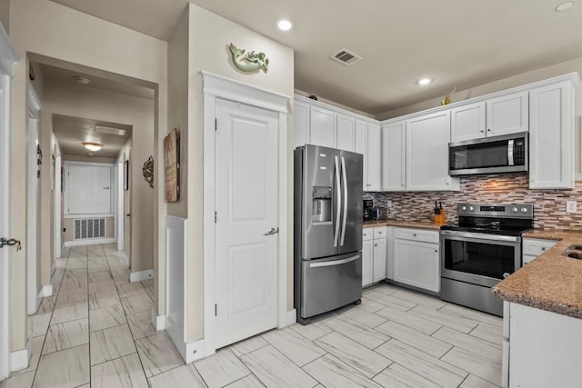 4121 Pointe W Dr Unit 103, Galveston, TX 77554 - kitchen with stainless steel appliances, white cabinetry, tasteful backsplash, recessed lighting, and light marble finish floors