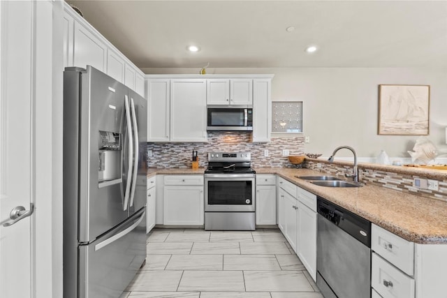 4121 Pointe W Dr Unit 103, Galveston, TX 77554 - kitchen featuring stainless steel appliances, white cabinets, decorative backsplash, light marble finish flooring, and recessed lighting