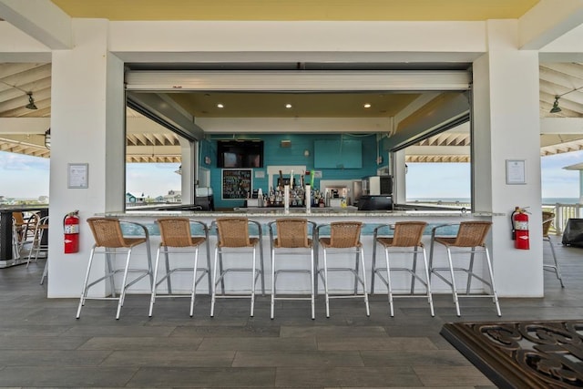 4121 Pointe W Dr Unit 103, Galveston, TX 77554 - kitchen with green cabinetry, dark wood-type flooring, and a breakfast bar