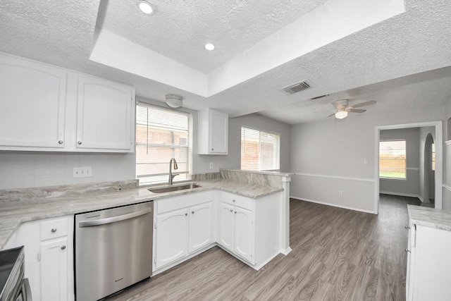 17715 Glenpatti Dr, Houston, TX 77084 - kitchen featuring stainless steel dishwasher, a textured ceiling, a peninsula, white cabinets, and light countertops