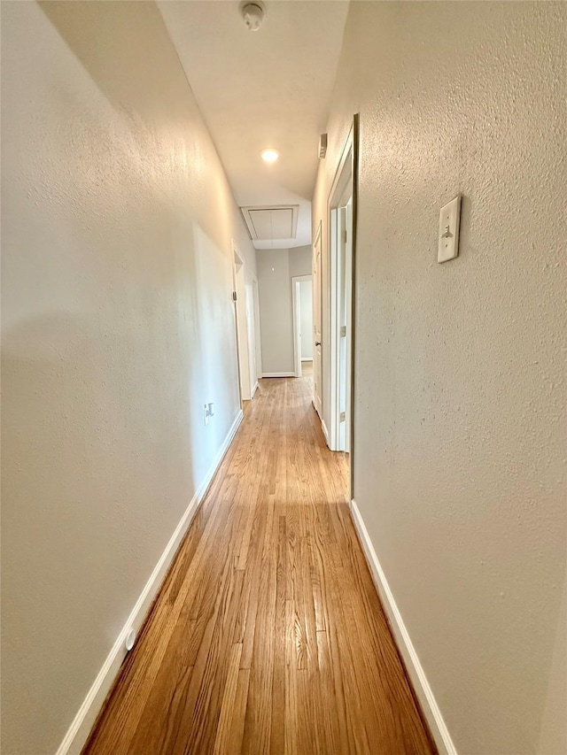 11418 Braewick Dr, Houston, TX 77035 - hall featuring attic access, wood finished floors, and a textured wall