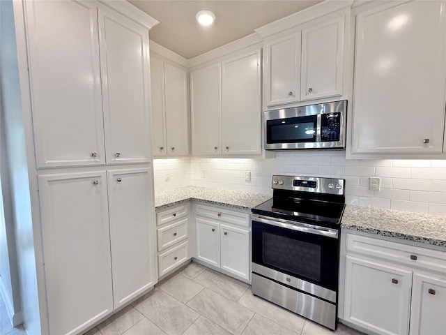 11418 Braewick Dr, Houston, TX 77035 - kitchen with appliances with stainless steel finishes, white cabinetry, tasteful backsplash, light stone countertops, and recessed lighting