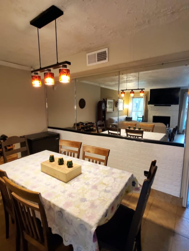 8728 Wilcrest Dr Unit 8728, Houston, TX 77099 - dining area featuring crown molding, a fireplace, and tile patterned flooring