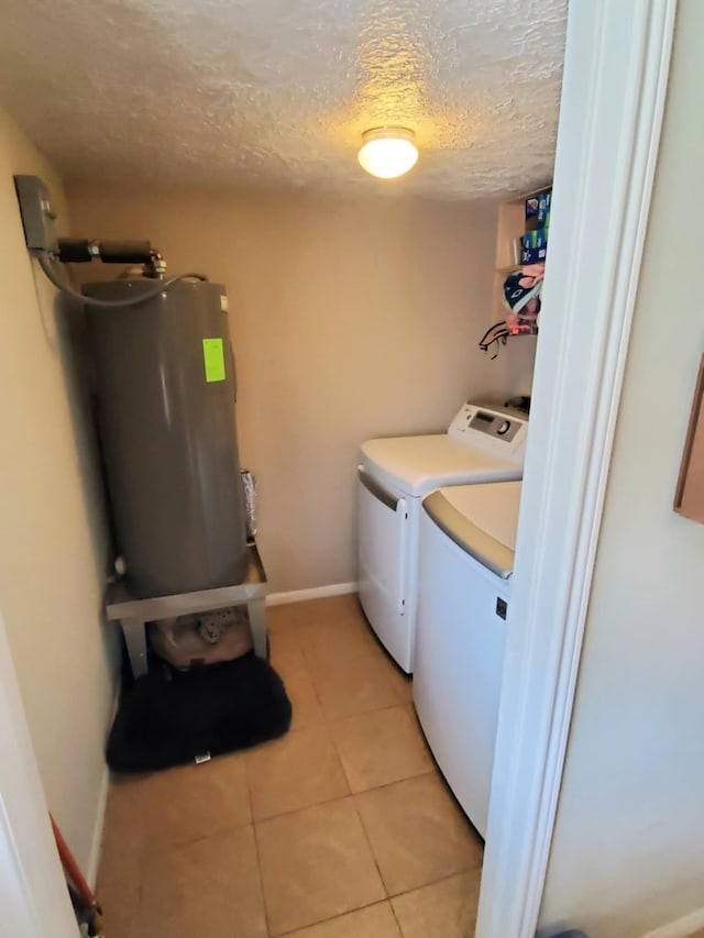 8728 Wilcrest Dr Unit 8728, Houston, TX 77099 - laundry room featuring independent washer and dryer, water heater, a textured ceiling, and light tile patterned flooring