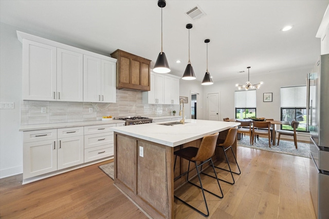 1810 Nauts Ct, Houston, TX 77008 - kitchen with backsplash, light wood-style floors, freestanding refrigerator, a center island with sink, and recessed lighting