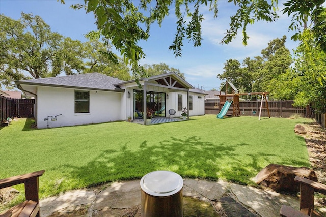 1810 Nauts Ct, Houston, TX 77008 - rear view of property featuring a fenced backyard, a playground, a shingled roof, and stucco siding