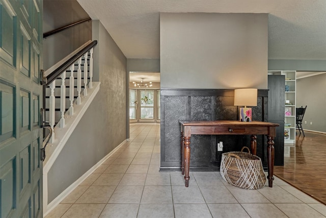 100 W Rainbow Ridge Cir, The Woodlands, TX 77381 - tiled living area with a chandelier, stairway, and a textured ceiling