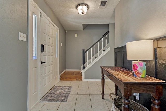 100 W Rainbow Ridge Cir, The Woodlands, TX 77381 - foyer entrance featuring light tile patterned floors, stairs, and a textured ceiling