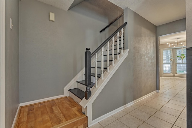 100 W Rainbow Ridge Cir, The Woodlands, TX 77381 - stairway featuring tile patterned floors and a chandelier