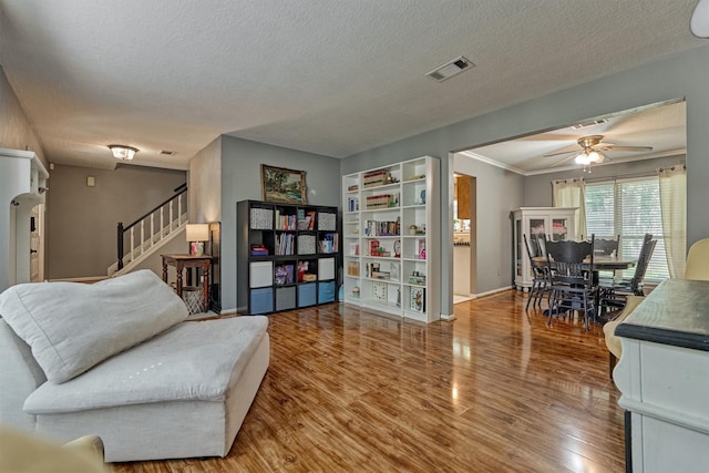 100 W Rainbow Ridge Cir, The Woodlands, TX 77381 - living area with wood finished floors, stairs, ceiling fan, and a textured ceiling