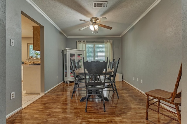 100 W Rainbow Ridge Cir, The Woodlands, TX 77381 - dining area with ceiling fan, healthy amount of natural light, wood finished floors, crown molding, and a textured ceiling