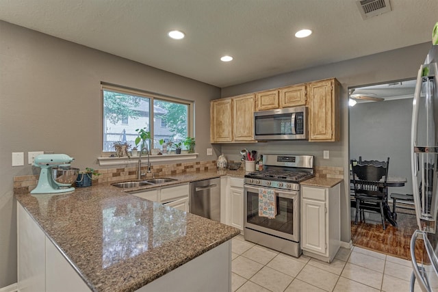 100 W Rainbow Ridge Cir, The Woodlands, TX 77381 - kitchen with appliances with stainless steel finishes, stone counters, a peninsula, light tile patterned floors, and recessed lighting