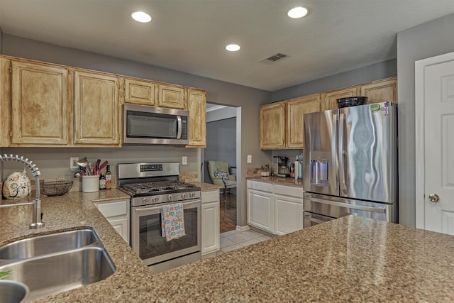 100 W Rainbow Ridge Cir, The Woodlands, TX 77381 - kitchen featuring stainless steel appliances, light tile patterned flooring, recessed lighting, and light stone countertops