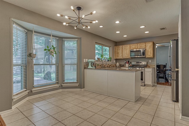 100 W Rainbow Ridge Cir, The Woodlands, TX 77381 - kitchen with stainless steel appliances, a chandelier, light tile patterned floors, recessed lighting, and a peninsula