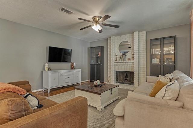 100 W Rainbow Ridge Cir, The Woodlands, TX 77381 - living room with a ceiling fan, wood finished floors, and a brick fireplace