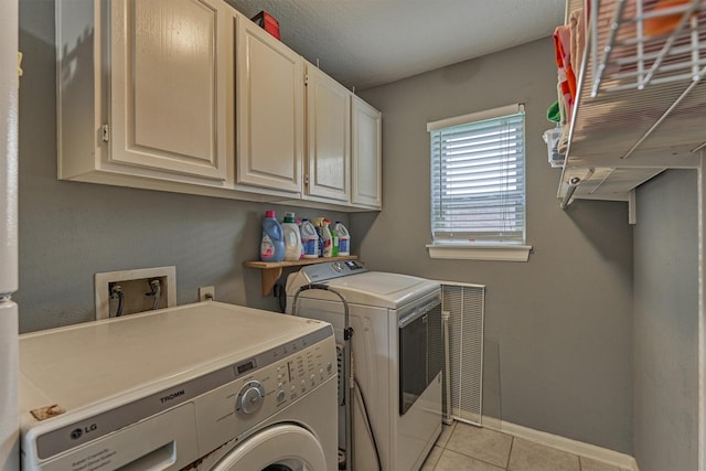 100 W Rainbow Ridge Cir, The Woodlands, TX 77381 - washroom with independent washer and dryer, cabinet space, and light tile patterned floors