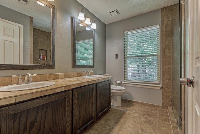 100 W Rainbow Ridge Cir, The Woodlands, TX 77381 - bathroom featuring double vanity, a textured ceiling, a textured wall, and tile patterned flooring