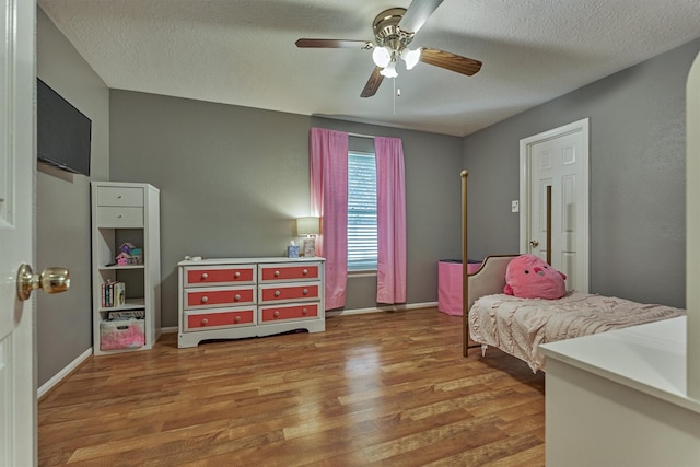 100 W Rainbow Ridge Cir, The Woodlands, TX 77381 - bedroom with wood finished floors, ceiling fan, and a textured ceiling
