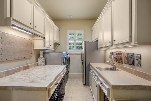 102 Lake Sterling Gate Dr, Spring, TX 77379 - washroom featuring washing machine and dryer, light tile patterned floors, and cabinet space
