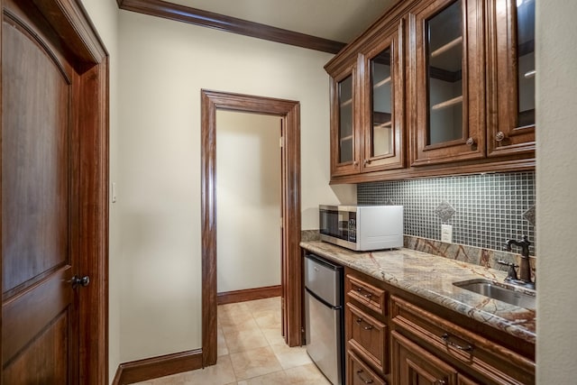 102 Lake Sterling Gate Dr, Spring, TX 77379 - kitchen with stainless steel microwave, refrigerator, crown molding, light stone countertops, and decorative backsplash