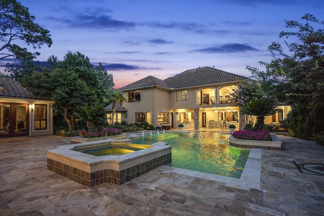 102 Lake Sterling Gate Dr, Spring, TX 77379 - rear view of property featuring a patio, a balcony, stucco siding, a tiled roof, and a pool with connected hot tub