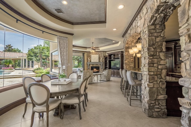 102 Lake Sterling Gate Dr, Spring, TX 77379 - dining room with a raised ceiling, crown molding, a fireplace, ceiling fan, and recessed lighting