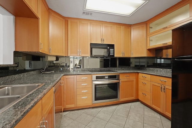5200 Weslayan St Unit 101, Houston, TX 77005 - kitchen featuring black appliances, light tile patterned floors, glass insert cabinets, and dark stone countertops
