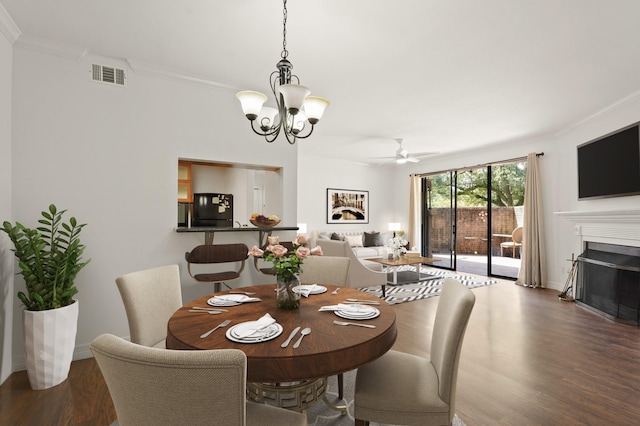 5200 Weslayan St Unit 101, Houston, TX 77005 - dining room featuring crown molding, a chandelier, wood finished floors, a fireplace, and ceiling fan