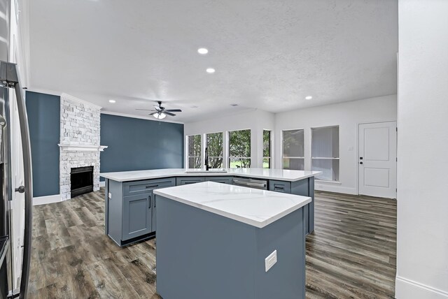 1826 Cheyenne River Cir, Sugar Land, TX 77478 - kitchen featuring a kitchen island, a stone fireplace, recessed lighting, gray cabinetry, and ceiling fan