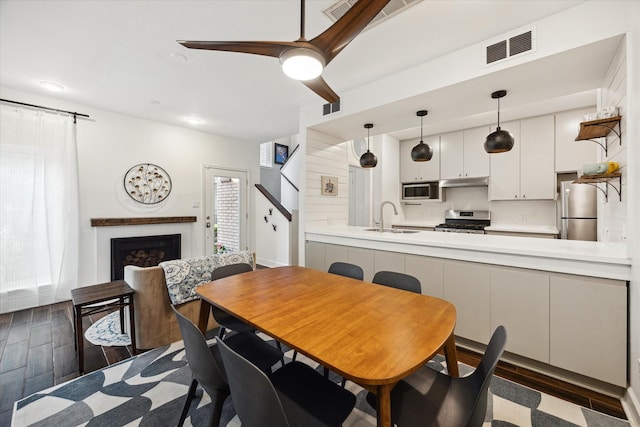 4914 Feagan St, Houston, TX 77007 - dining space with wood finished floors, a fireplace, a ceiling fan, and stairway