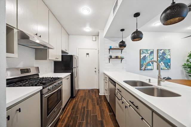 4914 Feagan St, Houston, TX 77007 - kitchen featuring appliances with stainless steel finishes, under cabinet range hood, dark wood-style floors, decorative backsplash, and light countertops