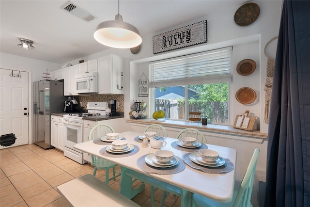 600 Erin Cir, Leander, TX 78641 - kitchen featuring white appliances, light tile patterned flooring, white cabinetry, backsplash, and dark countertops