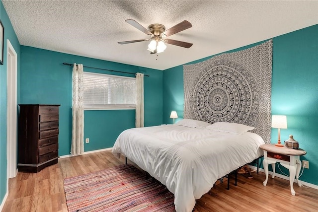 600 Erin Cir, Leander, TX 78641 - bedroom featuring wood finished floors, a textured ceiling, and a ceiling fan