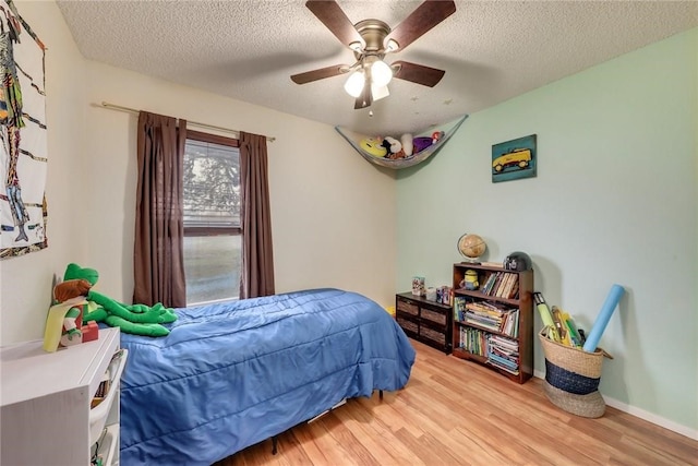 600 Erin Cir, Leander, TX 78641 - bedroom with wood finished floors, ceiling fan, and a textured ceiling
