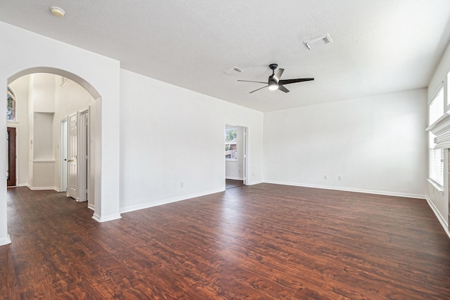 3242 Enchanted Hollow Ln, Spring, TX 77388 - empty room with a ceiling fan, arched walkways, healthy amount of natural light, and dark wood-style flooring