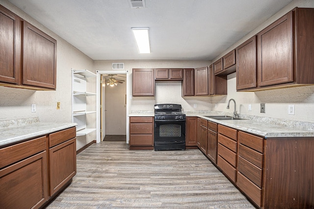 4028 N 1/2 Ave, Santa Fe, TX 77510 - kitchen featuring black range with gas stovetop, light wood-style flooring, light countertops, and a ceiling fan