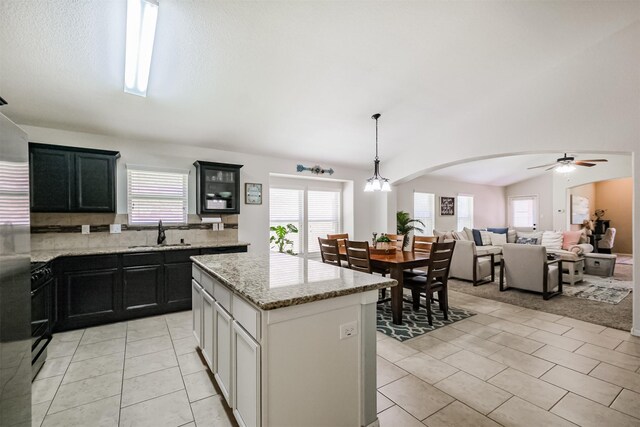 2010 Wembley Way, Rosenberg, TX 77471 - kitchen featuring healthy amount of natural light, a center island, ceiling fan, arched walkways, and lofted ceiling