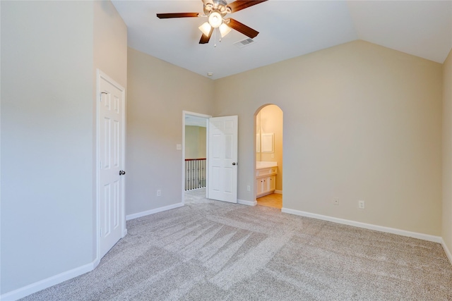5507 Opal Cove Ct, Katy, TX 77494 - unfurnished bedroom featuring arched walkways, light carpet, vaulted ceiling, ceiling fan, and ensuite bath