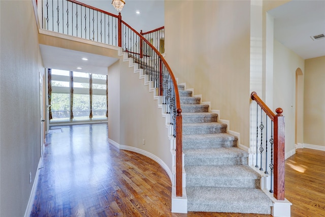 5507 Opal Cove Ct, Katy, TX 77494 - stairway with arched walkways, wood finished floors, and a towering ceiling