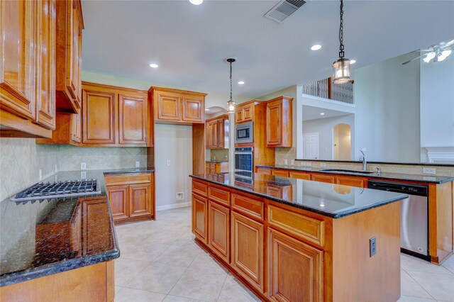 5507 Opal Cove Ct, Katy, TX 77494 - kitchen with appliances with stainless steel finishes, a kitchen island, decorative backsplash, dark stone countertops, and recessed lighting