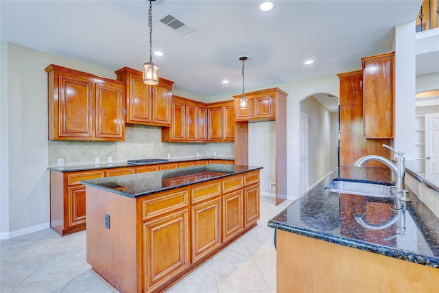 5507 Opal Cove Ct, Katy, TX 77494 - kitchen with arched walkways, dark stone countertops, brown cabinetry, recessed lighting, and tasteful backsplash