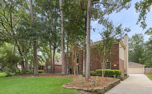 22 Windfern Pl, The Woodlands, TX 77382 - view of front of home with brick siding, a chimney, a front yard, and a garage