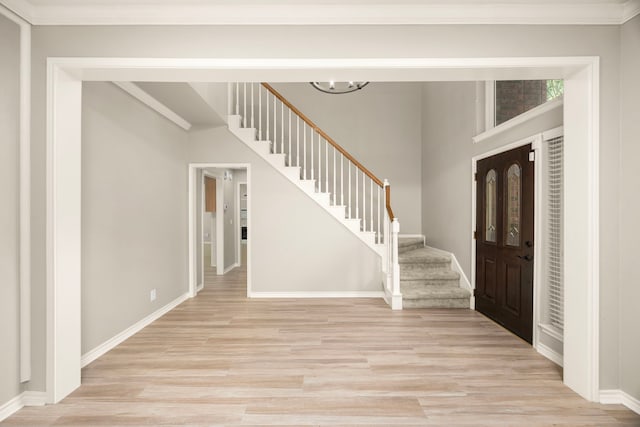 22 Windfern Pl, The Woodlands, TX 77382 - entryway with light wood-style floors, stairway, a chandelier, and ornamental molding