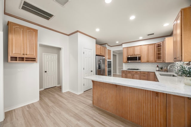 22 Windfern Pl, The Woodlands, TX 77382 - kitchen featuring stainless steel appliances, light wood-style floors, light stone countertops, a peninsula, and tasteful backsplash