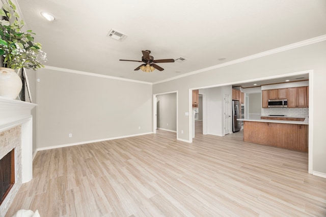 22 Windfern Pl, The Woodlands, TX 77382 - unfurnished living room featuring a fireplace, ceiling fan, crown molding, light wood-style flooring, and recessed lighting