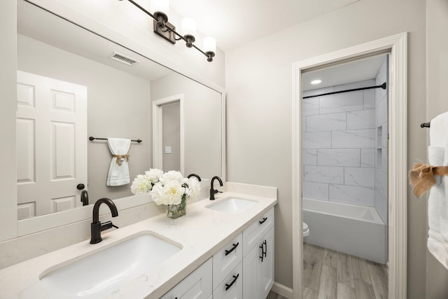 22 Windfern Pl, The Woodlands, TX 77382 - bathroom with double vanity, wood finished floors, and bathtub / shower combination