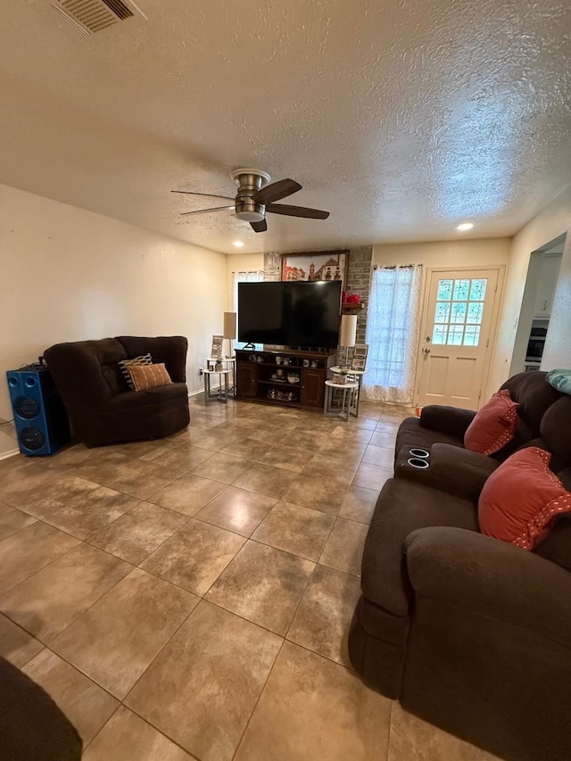 7431 Water Park Ln, Houston, TX 77086 - tiled living room featuring a ceiling fan and a textured ceiling