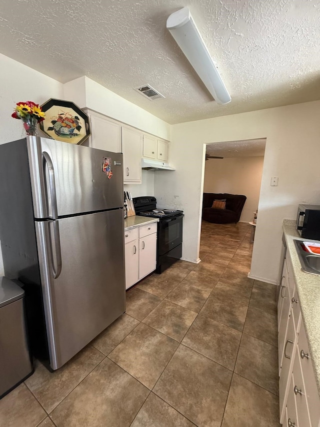 7431 Water Park Ln, Houston, TX 77086 - kitchen with black appliances, under cabinet range hood, light countertops, a textured ceiling, and white cabinetry