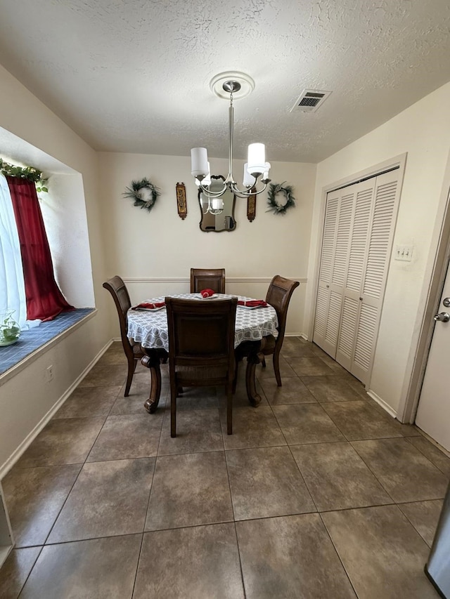 7431 Water Park Ln, Houston, TX 77086 - dining space with a chandelier, a textured ceiling, and dark tile patterned flooring