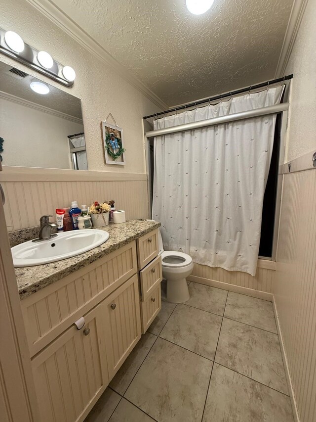 7431 Water Park Ln, Houston, TX 77086 - full bath with ornamental molding, vanity, tile patterned flooring, a textured ceiling, and wainscoting